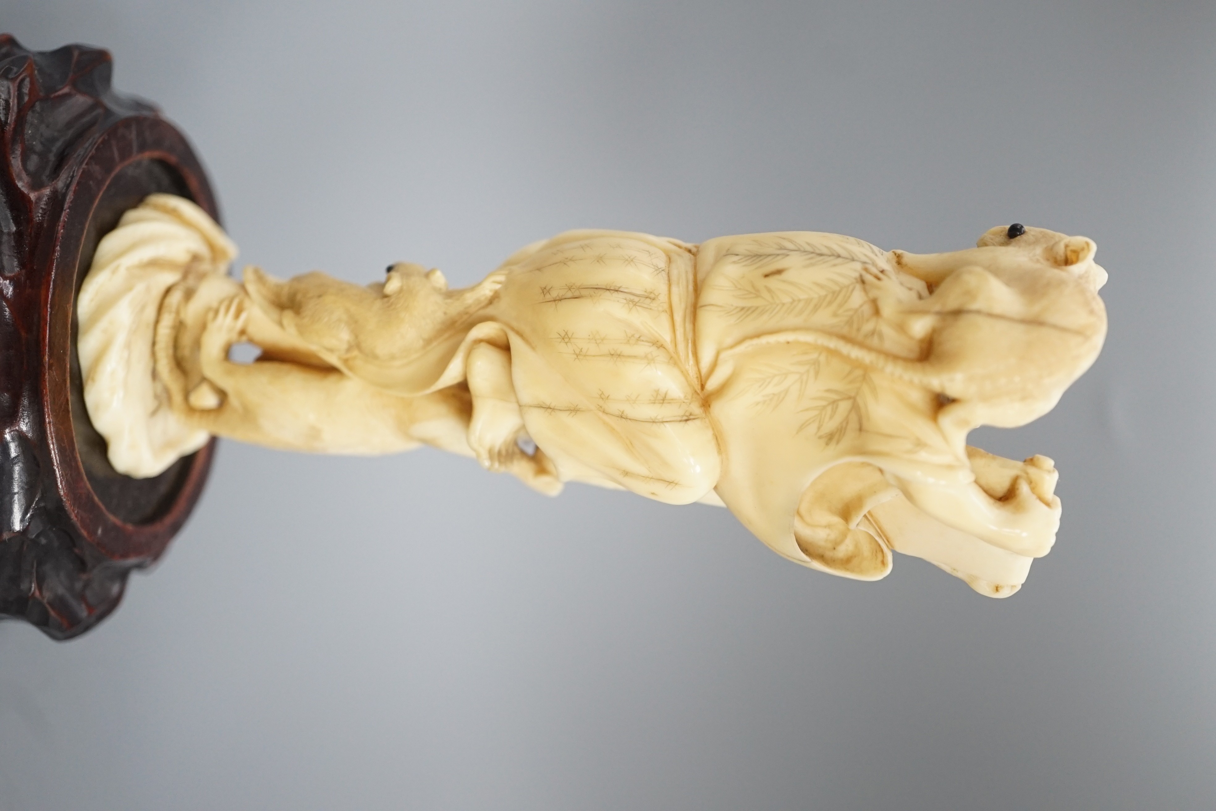 A Japanese ivory okimono of a man with giant rats clambering over him, signed, late 19th century 12.5cm, wood stand